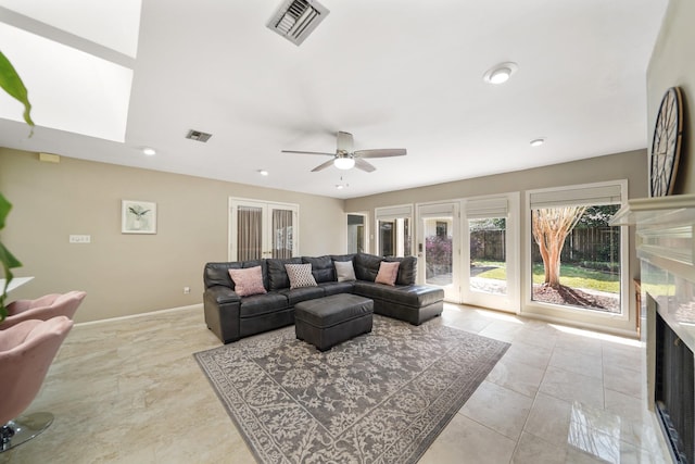 living area with visible vents, baseboards, a ceiling fan, and a fireplace