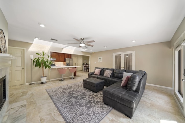 living room with visible vents, baseboards, ceiling fan, a premium fireplace, and recessed lighting