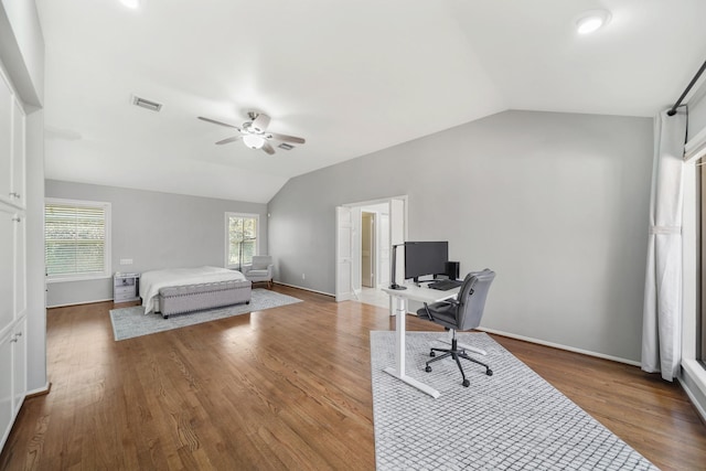 bedroom with visible vents, ceiling fan, baseboards, lofted ceiling, and wood finished floors