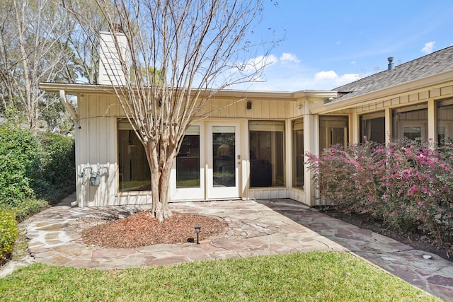 back of property with a patio area, french doors, and board and batten siding