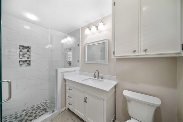 full bathroom with a marble finish shower, tile patterned flooring, toilet, and vanity