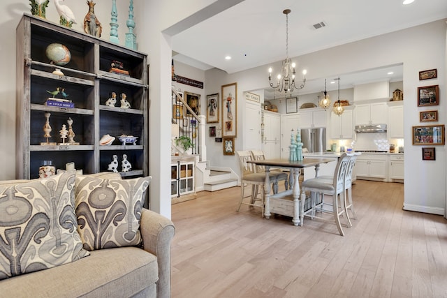 dining area with recessed lighting, stairway, a notable chandelier, and light wood-style flooring