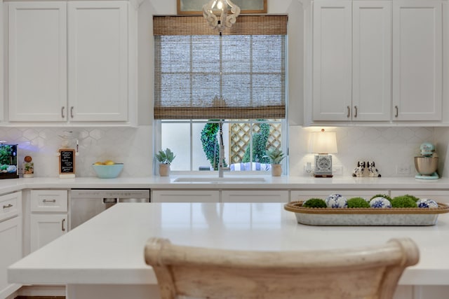 kitchen with dishwasher, light countertops, backsplash, and white cabinetry