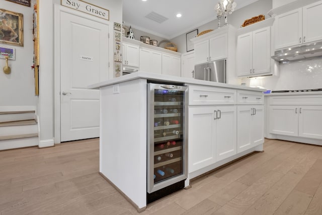 kitchen featuring light wood-type flooring, high quality fridge, beverage cooler, and white cabinetry