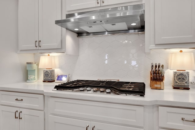 kitchen with under cabinet range hood, white cabinetry, light countertops, and stainless steel gas cooktop