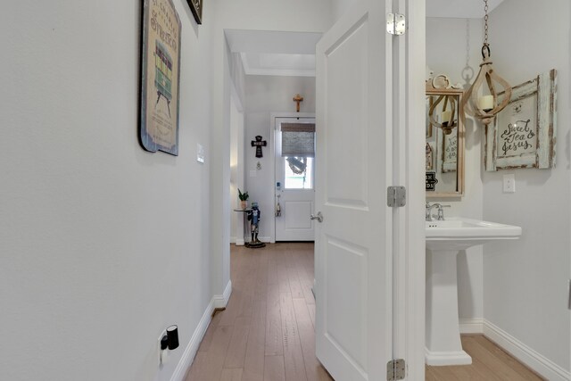 corridor featuring wood finished floors and baseboards