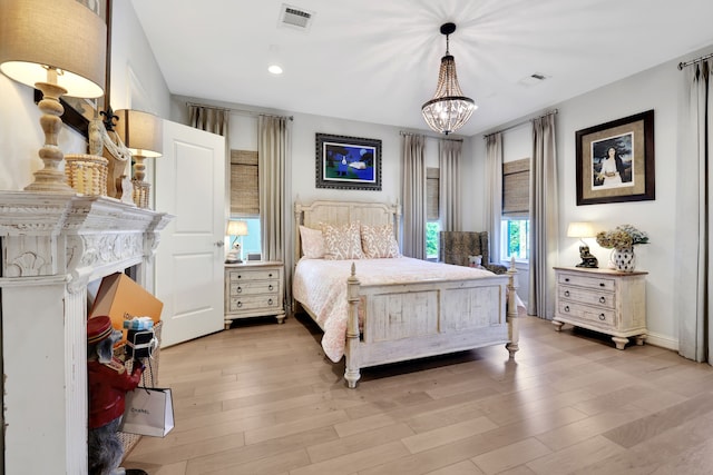 bedroom with a notable chandelier, visible vents, recessed lighting, and light wood-type flooring