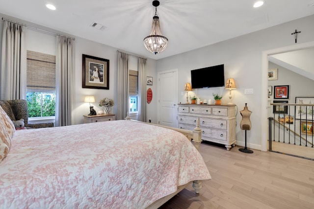 bedroom with baseboards, visible vents, light wood finished floors, recessed lighting, and a chandelier