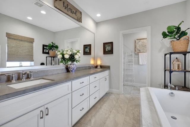 bathroom with a bathtub, visible vents, double vanity, and a sink