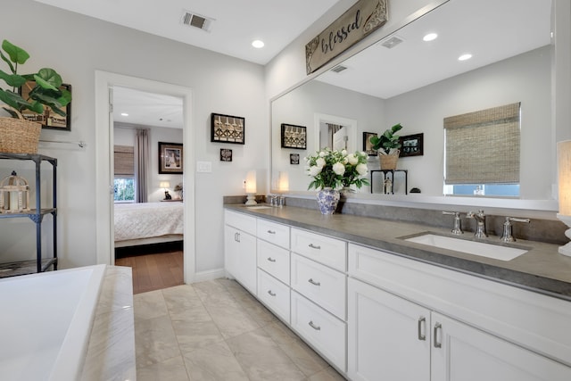 ensuite bathroom featuring a sink, visible vents, recessed lighting, and double vanity