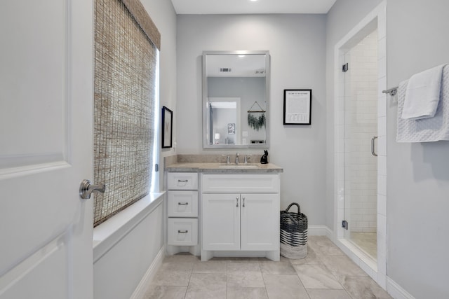 bathroom with a wealth of natural light, a stall shower, vanity, and baseboards