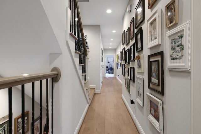 corridor with stairs, light wood-style flooring, recessed lighting, and baseboards