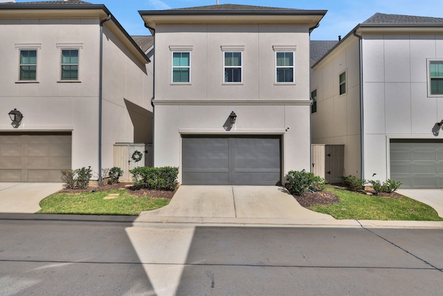 view of front of home with stucco siding, driveway, and an attached garage