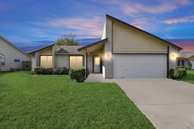 mid-century inspired home featuring brick siding, concrete driveway, cooling unit, a yard, and a garage