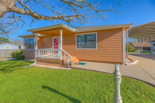 view of front of home featuring a detached carport, a front lawn, and fence