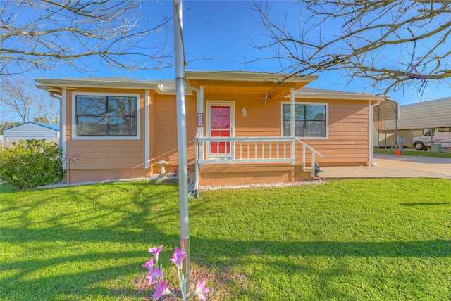 view of front of home with driveway, a carport, and a front lawn