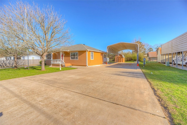 view of front of home with a carport, fence, a front yard, and driveway