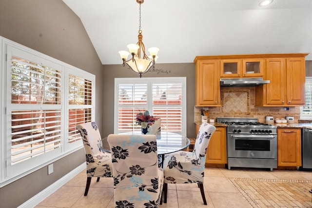 dining area featuring light tile patterned flooring, a notable chandelier, baseboards, and lofted ceiling