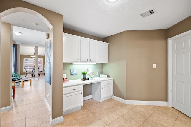 office area featuring visible vents, built in desk, light tile patterned flooring, decorative columns, and baseboards