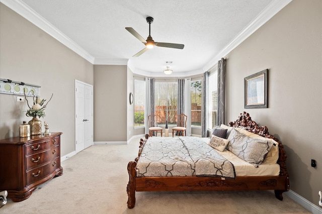 bedroom featuring a ceiling fan, baseboards, ornamental molding, a textured ceiling, and light colored carpet