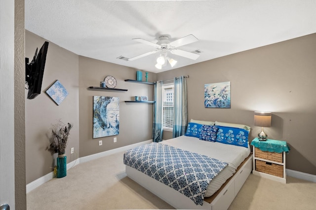 carpeted bedroom featuring visible vents, baseboards, a textured ceiling, and ceiling fan