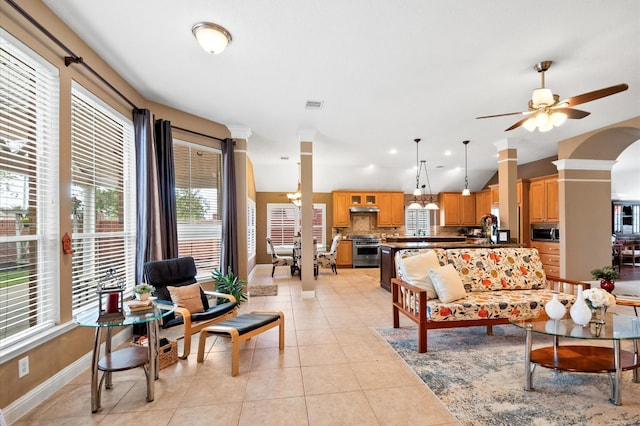 living area featuring visible vents, baseboards, ceiling fan, decorative columns, and light tile patterned floors