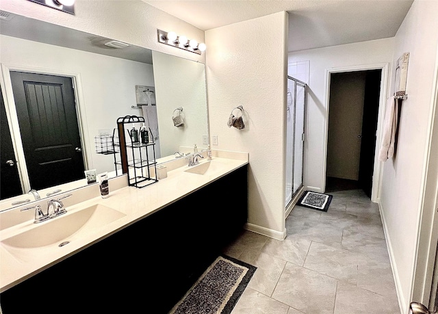 full bathroom with visible vents, baseboards, double vanity, a sink, and a shower stall