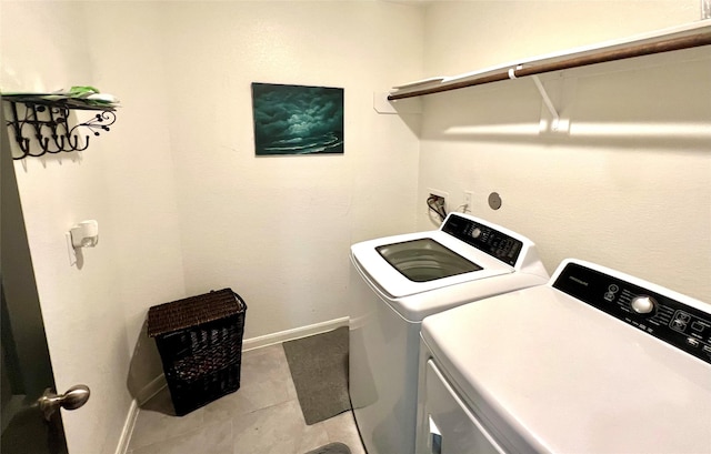 clothes washing area featuring laundry area, independent washer and dryer, and baseboards