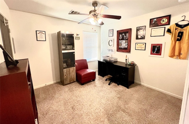 carpeted home office with baseboards and a ceiling fan