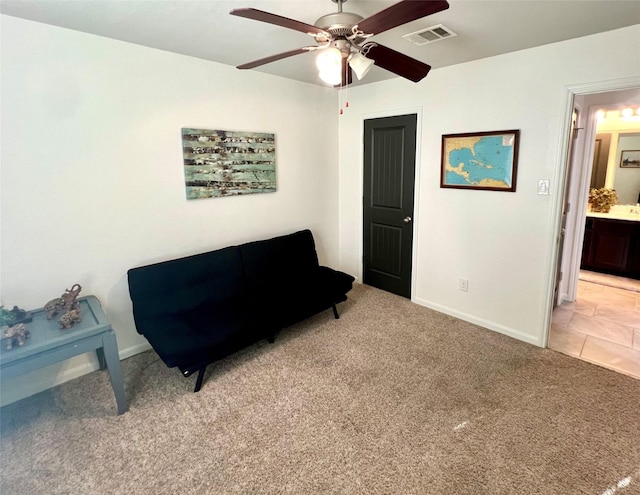 living area with ceiling fan, baseboards, visible vents, and light carpet