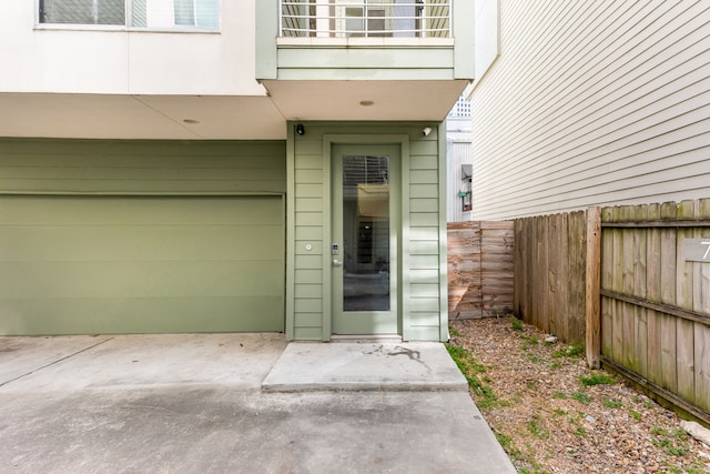 entrance to property with a patio, a balcony, and fence