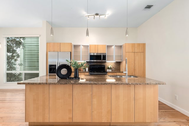 kitchen with visible vents, a spacious island, a sink, decorative backsplash, and stainless steel appliances