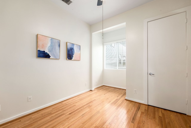 unfurnished bedroom featuring visible vents, baseboards, wood finished floors, and a ceiling fan