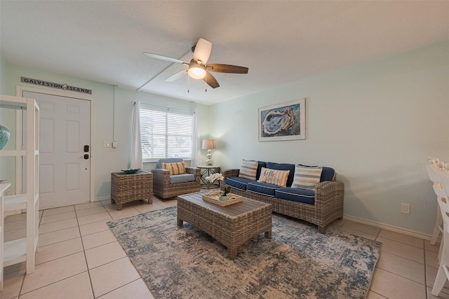 living area with light tile patterned floors, baseboards, and ceiling fan