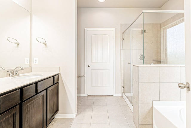 full bathroom featuring a garden tub, a stall shower, tile patterned flooring, baseboards, and vanity