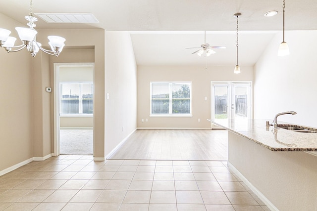 interior space with visible vents, ceiling fan with notable chandelier, a sink, light tile patterned floors, and vaulted ceiling