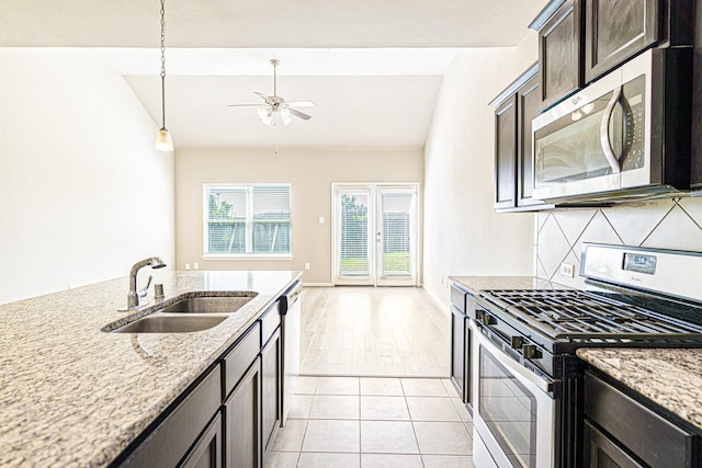 kitchen with ceiling fan, decorative backsplash, vaulted ceiling, a sink, and appliances with stainless steel finishes