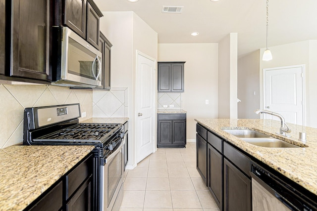 kitchen with light tile patterned floors, light stone counters, visible vents, a sink, and appliances with stainless steel finishes