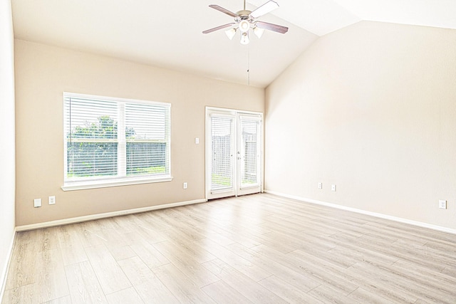 empty room with lofted ceiling, baseboards, light wood-type flooring, and a ceiling fan