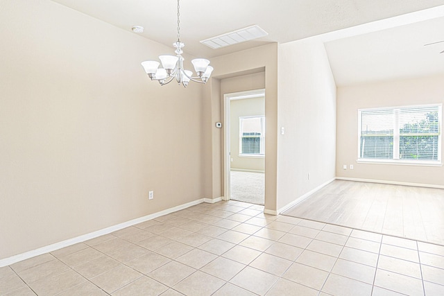 spare room featuring visible vents, baseboards, light tile patterned flooring, vaulted ceiling, and a notable chandelier