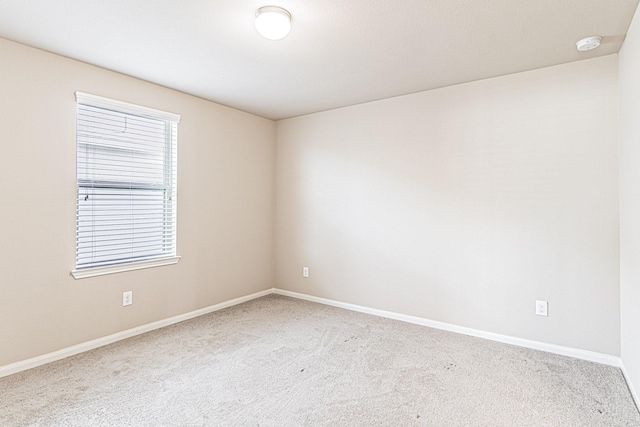 carpeted spare room with baseboards