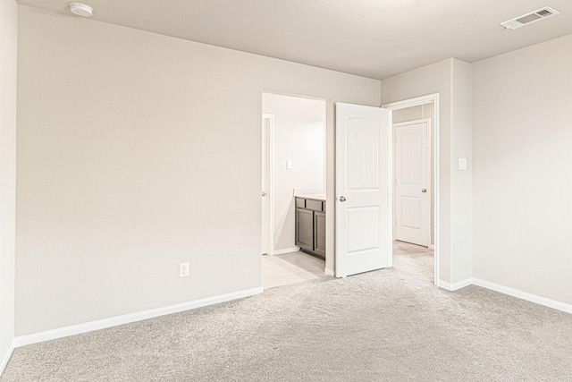 unfurnished room with visible vents, baseboards, and light colored carpet