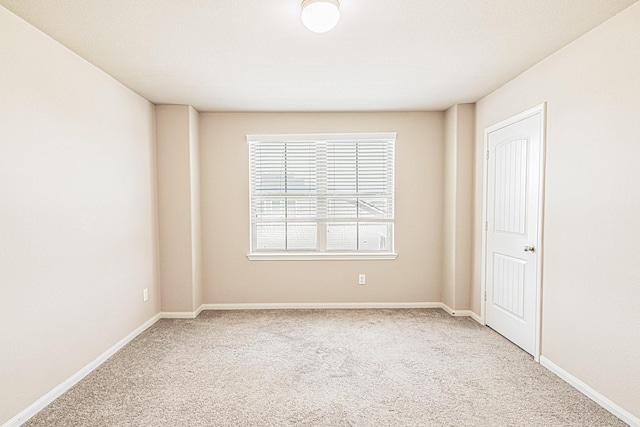 empty room featuring baseboards and carpet