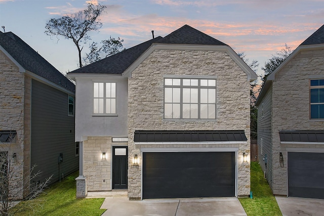 view of front of property with an attached garage, stone siding, and driveway