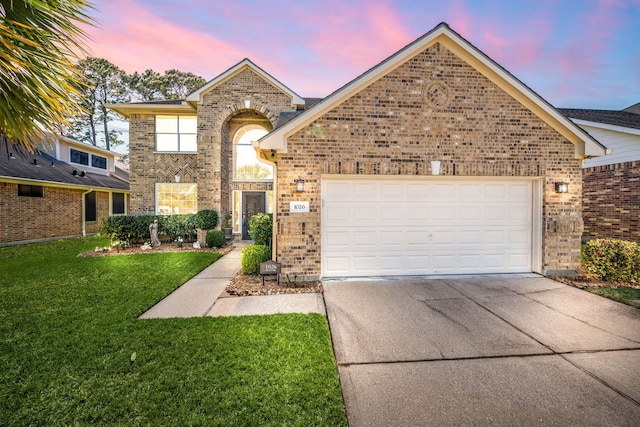 view of front facade featuring a garage, brick siding, concrete driveway, and a front lawn