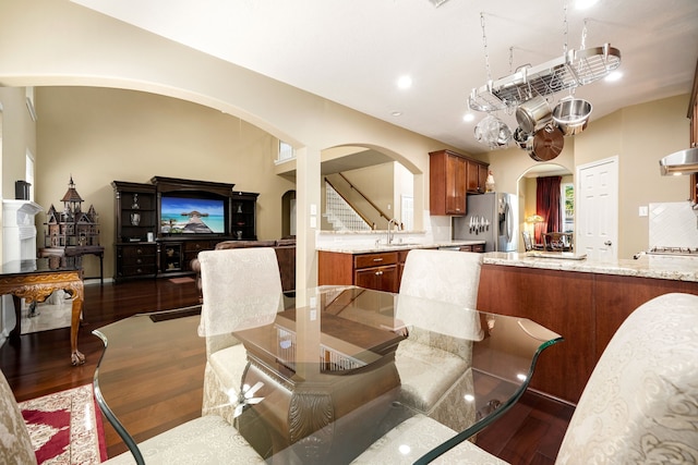 dining area with stairs, recessed lighting, arched walkways, and dark wood-style flooring