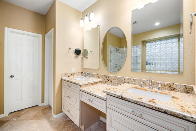 full bath with double vanity, visible vents, a tile shower, and a sink