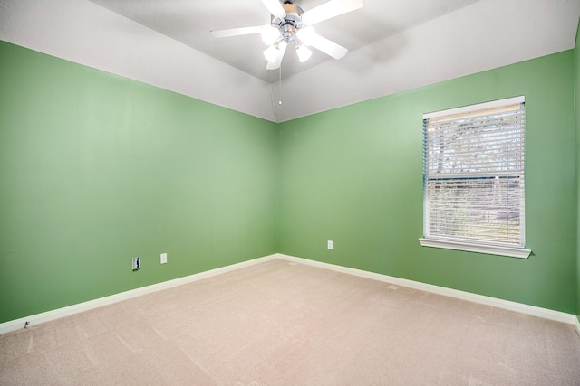 carpeted empty room featuring baseboards, lofted ceiling, and ceiling fan