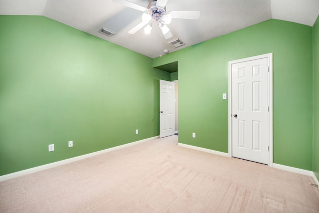 unfurnished bedroom with visible vents, baseboards, carpet flooring, and vaulted ceiling