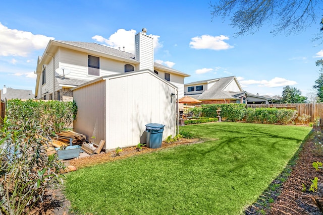 rear view of property featuring a yard, a chimney, and fence